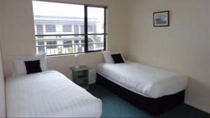 מיטה או מיטות בחדר ב-ASURE Abode On Courtenay Motor Inn