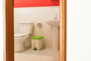 a bathroom with a toilet and a sink at Pousada das Flores in Gonçalves