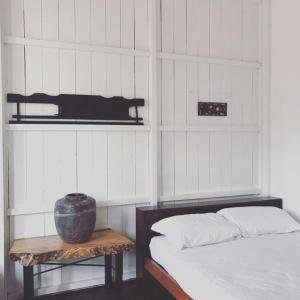 a bedroom with two beds and a table with a vase on it at Rareheart Guesthouse in Kuala Terengganu