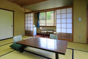 a dining room with a wooden table and chairs at Biwaike Hotel in Yamanouchi