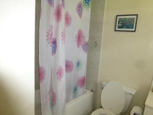 a bathroom with a toilet and a shower curtain at Hastings Towers 3B Opp Sea 2 Bed 2 Bath in Bridgetown