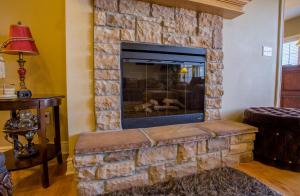 a living room with a stone fireplace at Tuscany Hills Villa in Hollister