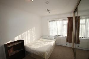 a white room with a bed and a tv at Hill Crescent in London