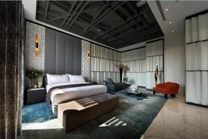 een slaapkamer met een groot bed en een rode stoel bij Ease Motel Taichung in Taichung