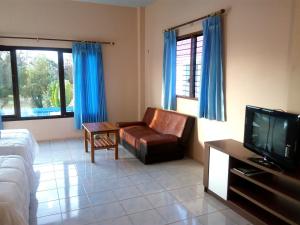 a living room with a couch and a television at Peace Pool Resort in Khun Han