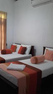3 posti letto in una camera con rosso e bianco di The European Gate - Anuradhapura a Anuradhapura