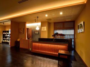 a restaurant with a bar in the middle of a room at Okuno Hosomichi in Kobe