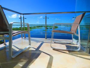 a balcony with chairs and a view of the water at Boulevard 251 Riverside Apartments in Iquitos