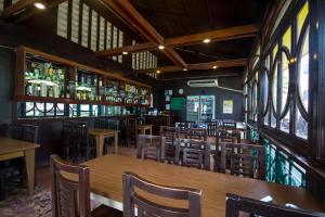 Microtel by Wyndham Eagle Ridge في General Trias: مطعم بطاولات وكراسي خشبية وبار