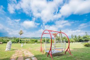 un parco giochi con un'altalena rossa in un parco di Shangri Longluan Lake One B&B a Città Vecchia di Hengchun