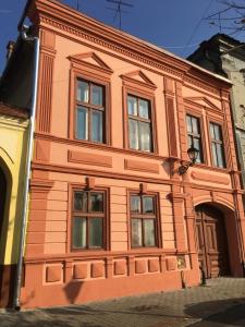 an orange building with windows on a street at Anastasia in Mediaş