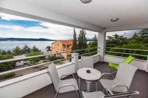 a balcony with a table and chairs and a view of the water at Apartments Vista in Novi Vinodolski