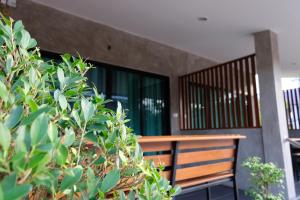 un banco de madera sentado frente a un edificio en Nam Sai Loft Resort, en Chao Lao Beach