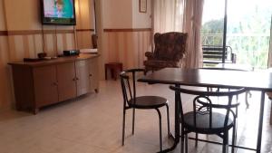 ein Wohnzimmer mit Tisch und Stühlen und einem Fernseher in der Unterkunft Genting Sempah Berjaya Hill Cottage in Bukittinggi + 29 Fotos