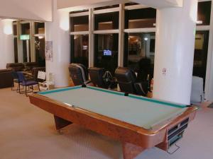 a pool table in a room with chairs at Shimoda Itoen Hotel Hanamisaki in Shimoda