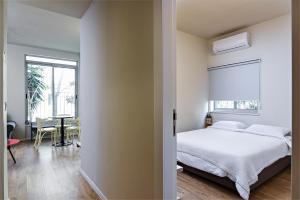 a bedroom with a bed and a table and a window at Hanasi 129 - Boutique Apartments in Haifa