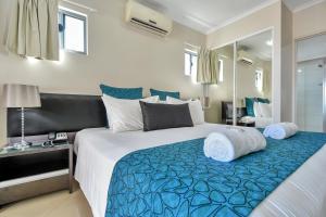 a bedroom with a large bed with a blue blanket at Argus Apartments Darwin in Darwin