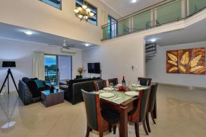a dining room and living room with a table and chairs at Argus Apartments Darwin in Darwin