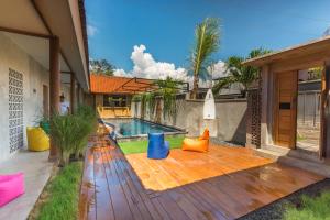 a backyard with a swimming pool and a wooden deck at Surfer Garden in Sanur