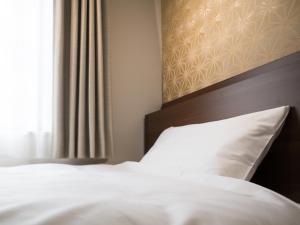 Postel nebo postele na pokoji v ubytování Tosei Hotel Cocone Kanda