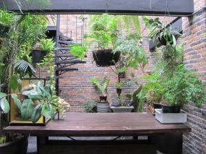 einem Holztisch mit Pflanzen an einer Ziegelmauer in der Unterkunft J No.14 in Bangkok