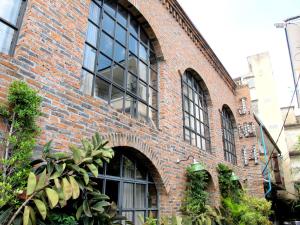 a red brick building with windows and plants at J No.14 in Bangkok