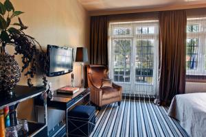 a hotel room with a bed and a chair and a desk at Boutique Hotel Poppenbütteler Hof in Hamburg