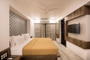 a hotel room with a bed and a tv at Hotel Sanmukh By Adamo in Nāthdwāra