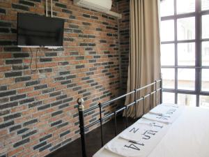 a room with a brick wall and a tv on a wall at J No.14 in Bangkok