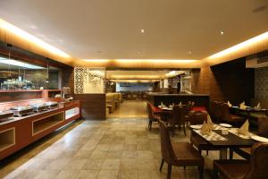 a restaurant with tables and chairs and a bar at The Contour Hotel in Guwahati