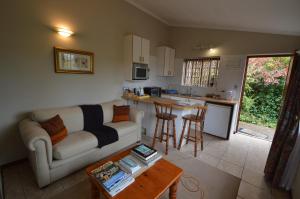 a living room with a couch and a table at Bayside Lodge Garden Route B&B in Plettenberg Bay