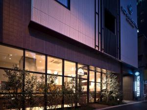 una tienda frente a un edificio por la noche en Tosei Hotel Cocone Kanda, en Tokio