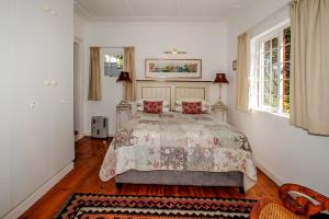 a bedroom with a large bed with red pillows at Salop House in Fish Hoek