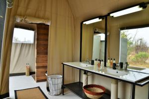 a bathroom with a sink and a mirror at Nogatsaa Pans Chobe Lodge in Kasane +38 photos