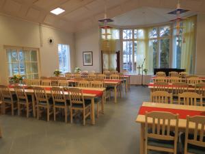 ein Esszimmer mit Tischen, Stühlen und Fenstern in der Unterkunft Luontoleirikeskus Lankari in Seinäjoki