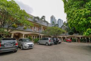 una fila de autos estacionados frente a un edificio en Reddoorz Plus @ Karet Pedurenan 3, en Yakarta