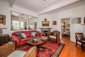 a living room with a red couch and a table at Salop House in Fish Hoek