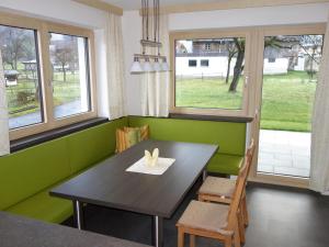 a dining room with a table and chairs and windows at Apart Haun in Stumm