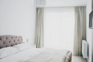 a bedroom with a bed and a large window at Apartament 4Tourists in Braşov