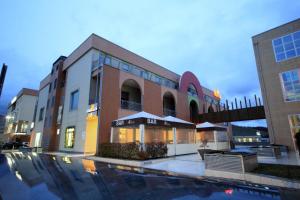 un edificio con piscina di fronte a un edificio di I Rocchi Hotel a Tito