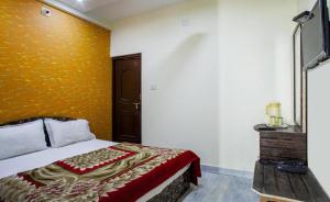 1 dormitorio con cama y pared amarilla en Hotel Hari Home, en Udaipur