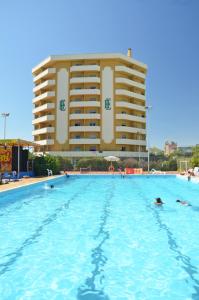 a swimming pool with a large building in the background at Grand Eurhotel in Montesilvano