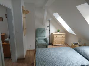 um quarto com uma cama, uma cadeira e uma cómoda em ubytovani u Javoru 232/8 em Pec pod Sněžkou