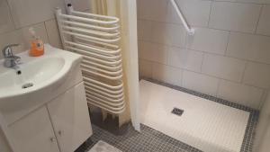 a white bathroom with a sink and a shower at Ferienhaus Karall in Klingenbach +4 photos