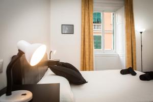 1 dormitorio con 1 cama con lámpara y ventana en Leone X Genova Affittacamere en Génova