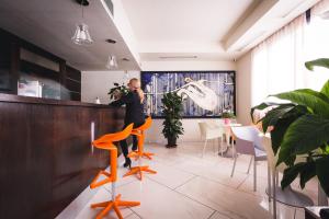 a man is standing at a bar in a restaurant at Inn Hotel in Barberino di Mugello