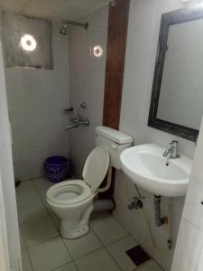 een badkamer met een toilet en een wastafel bij Sugar Plum Macedo Palms in Baga