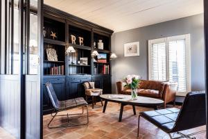 a living room with a couch and a table and chairs at Hotel Les Bois Flottais in Le Bois-Plage-en-Ré