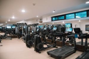アディスアベバにあるGolden Tulip Addis Ababaのトレッドミルとエリプティカルマシンが並ぶジム