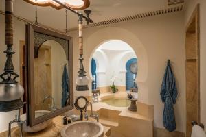 a bathroom with a tub and a sink and a mirror at Four Seasons Resort Langkawi in Tanjung Rhu
